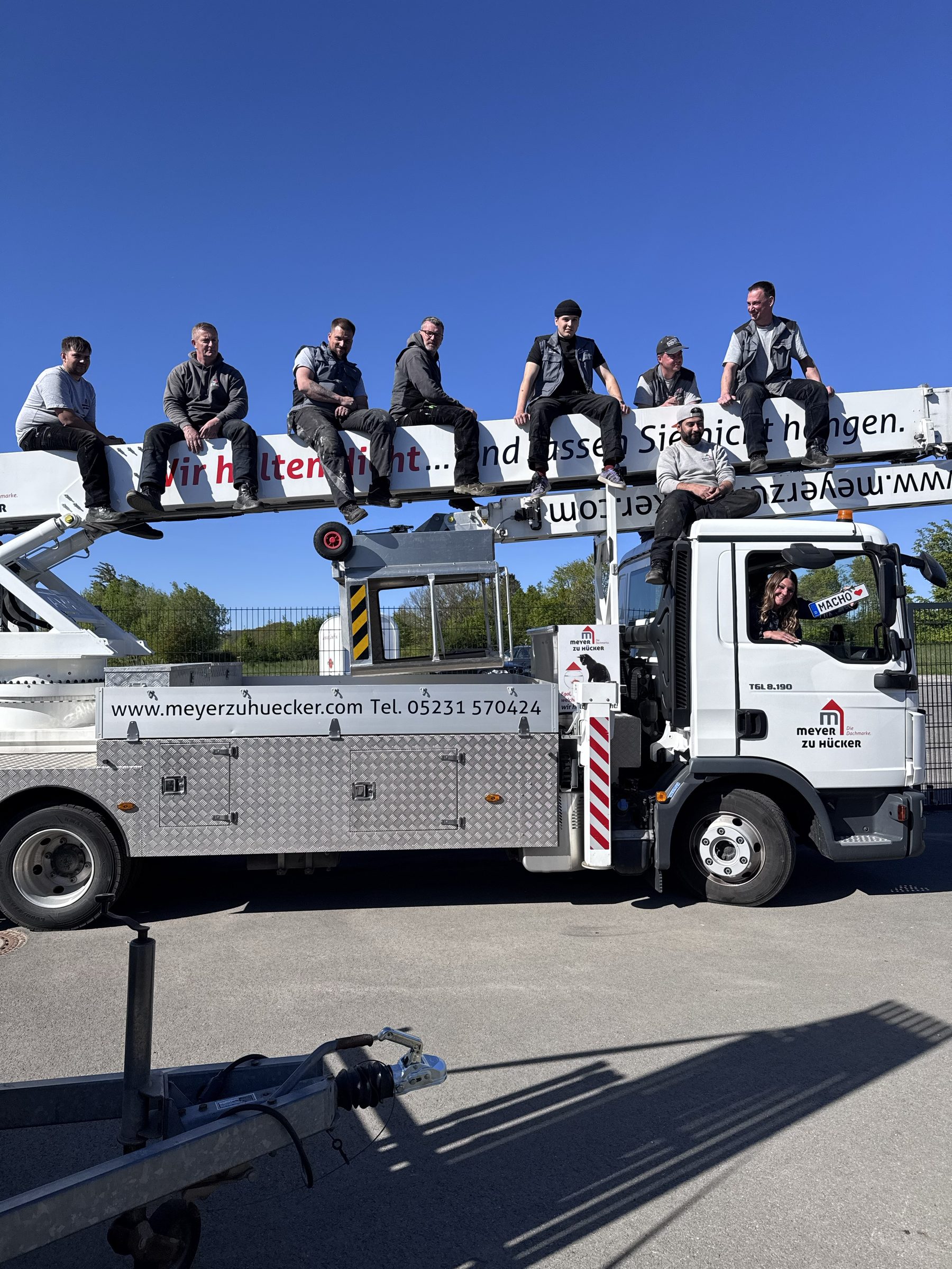 Das Team sitzt auf dem Kran-Ausleger